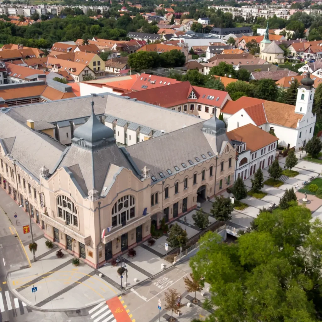 Légifelvétel egy századfordulós, díszes homlokzatú szállodaépületről egy városi környezetben.
